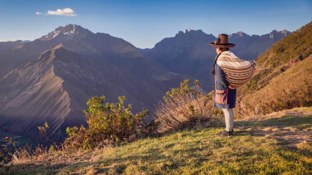 Young Peruvian woman looking at Peruvian Andes, The Sacred Valley.The Sacred Valley of the Incas or Urubamba Valley is a valley in the Andes  of Peru, close to the Inca capital of Cusco and below the ancient sacred city of Machu Picchu. The valley is generally understood to include everything between Pisac  and Ollantaytambo, parallel to the Urubamba River, or Vilcanota River or Wilcamayu, as this Sacred river is called when passing through the valley. It is fed by numerous rivers which descend through adjoining valleys and gorges, and contains numerous archaeological remains and villages. The valley was appreciated by the Incas due to its special geographical and climatic qualities. It was one of the empire's main points for the extraction of natural wealth, and the best place for maize production in Peru.
