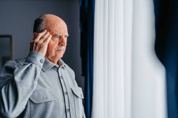 istock Worried Senior Man Looking Out The Window 2200151099