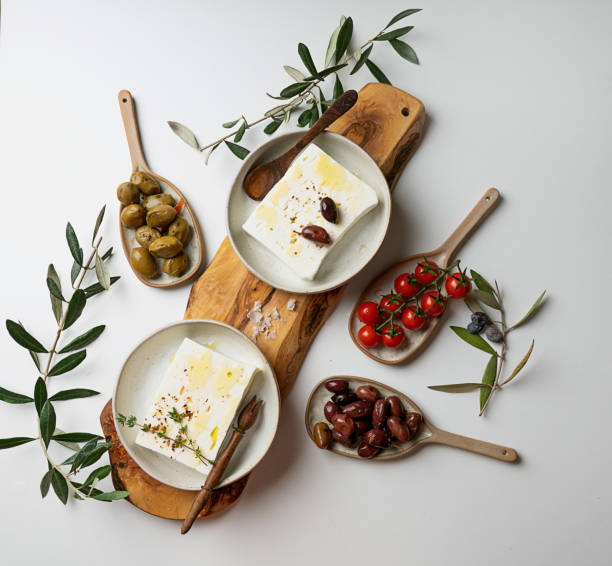 istock Traditional Greek Feta cheese with olive branches over the olive tree board 2200151426