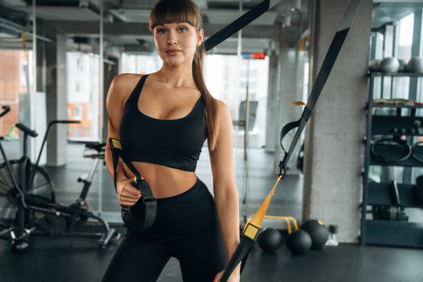 istock Pulls elastic ropes. Young woman is in the gym 2200154358