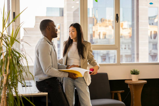 istock Business colleagues discussing project in modern office with city view 2200157979