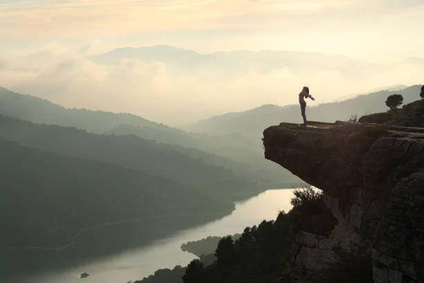 istock Woman outstretching celebrating in a cliff 2200160510
