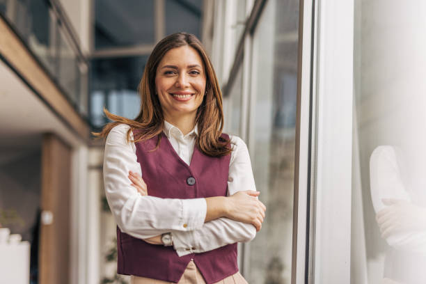 istock Confident businesswoman smiling with folded arms in modern office 2200161895