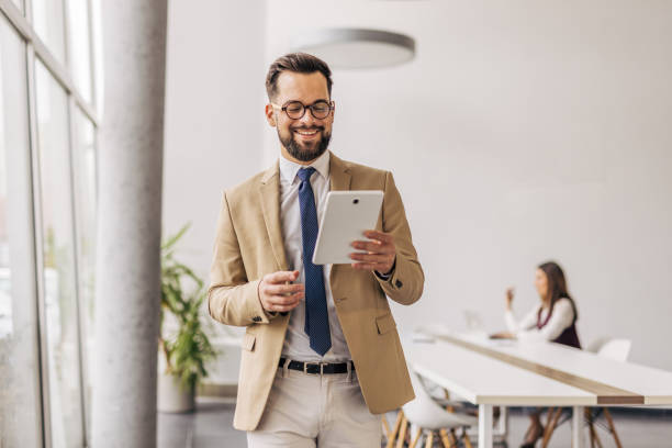 istock Businessman engaging with digital tablet in modern office 2200162569