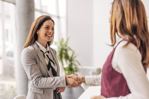 istock Professional women shaking hands in office setting 2200162642
