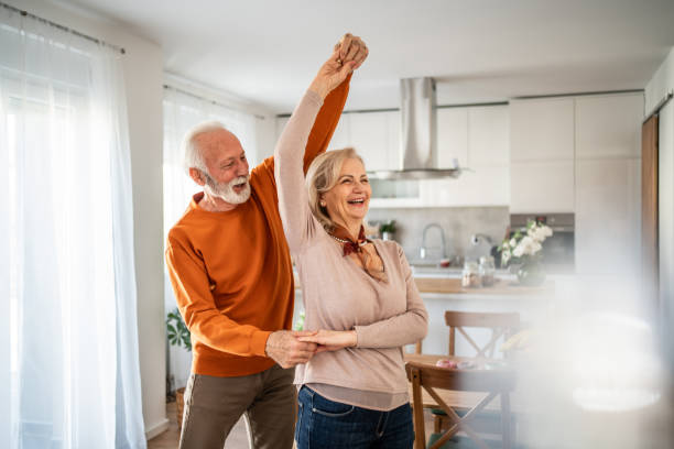 istock Happy senior couple dancing together in their modern kitchen 2200162817