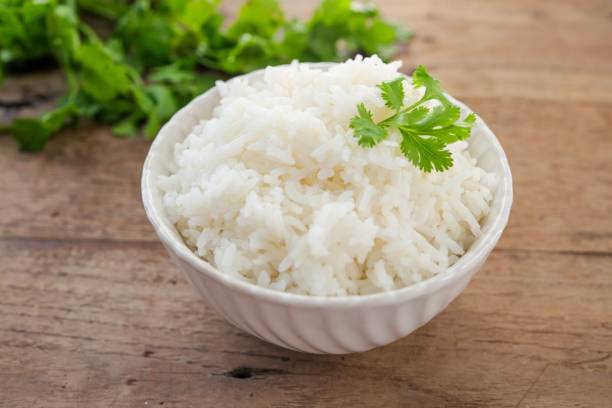 istock Cooked white rice or steamed rice in a white bowl on wooden background 2200163065