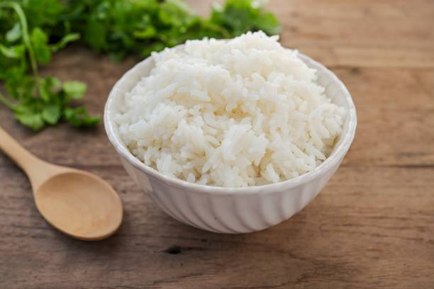 istock Cooked white rice or steamed rice in a white bowl on wooden background 2200163088