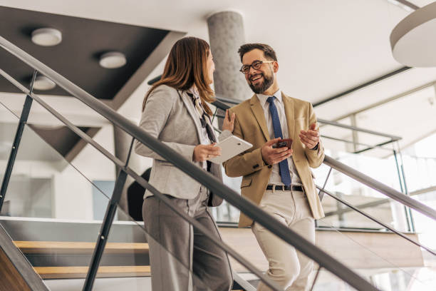 istock Businesspeople walking and talking on stairs in modern office 2200164263
