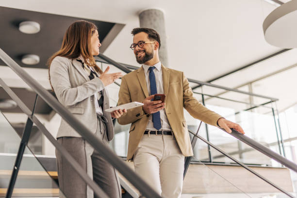 istock Business colleagues walking and talking on stairs in modern office 2200164267