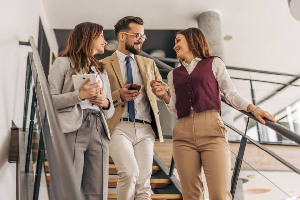 istock Businesspeople walking and talking on stairs in office 2200164373