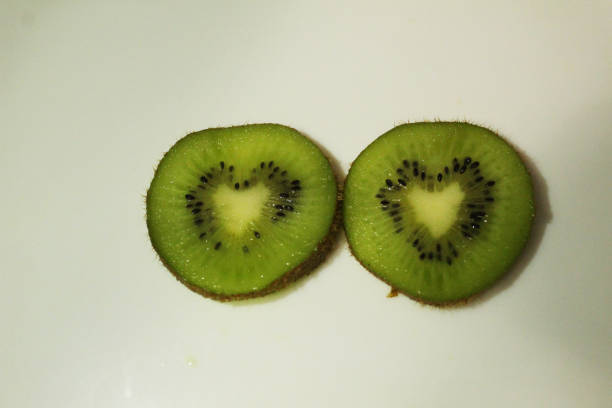 Kiwi in a heart-shaped cut on a white background, top view. Fruit Heart.