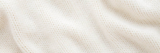 istock Light white wavy soft knitted fabric background. Closeup. Wide banner. Top down view. 2200168228