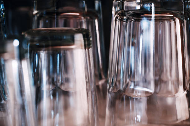 Set of empty clean drinking glasses on kitchen counter top after washing, selective focus