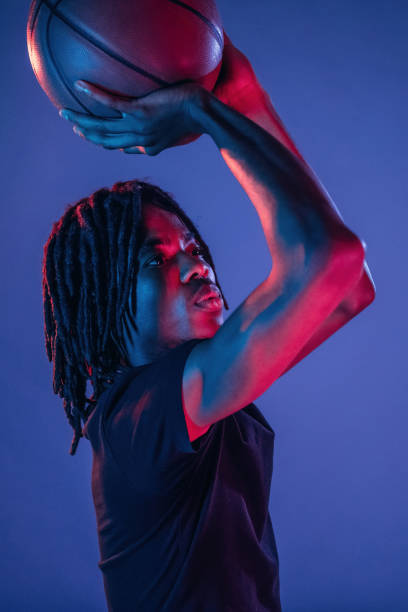 istock Throwing the ball. African American guy is studio with neon lighting 2200172070