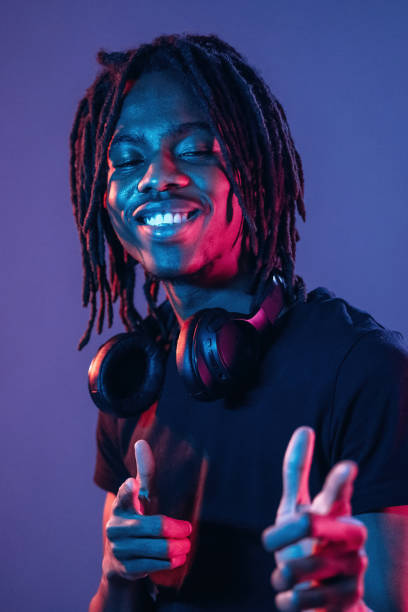 istock Friendly and cheerful facial expression. African American guy is studio with neon lighting 2200172706