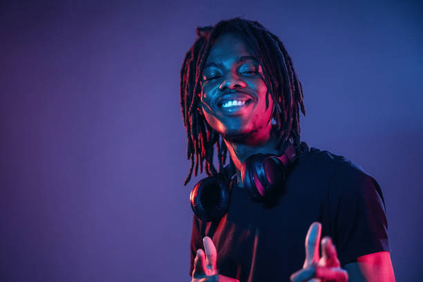 istock Friendly and cheerful facial expression. African American guy is studio with neon lighting 2200172766