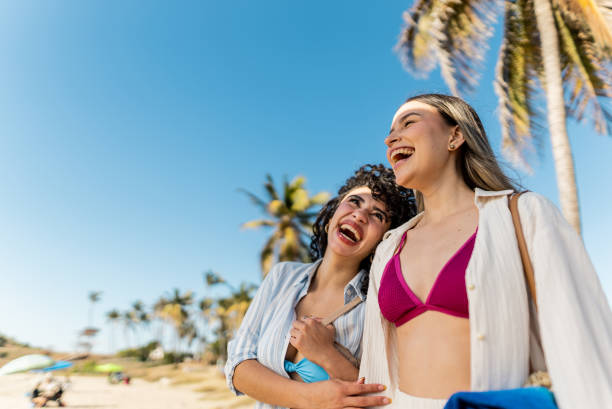 istock Friends women talking and walking through the beach 2200179576