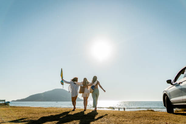 istock Young friends women celebrating while arriving on the beach 2200179725