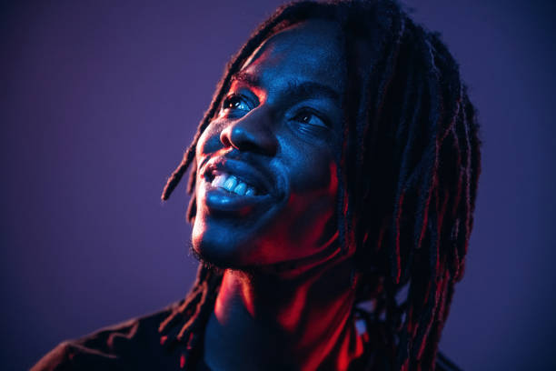 istock Close up portrait. African American guy is studio with neon lighting 2200180044