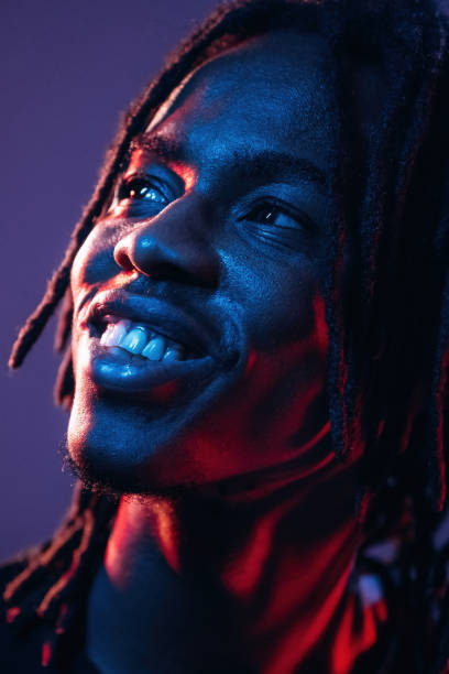istock Smiling, positive facial expression. African American guy is studio with neon lighting 2200180065