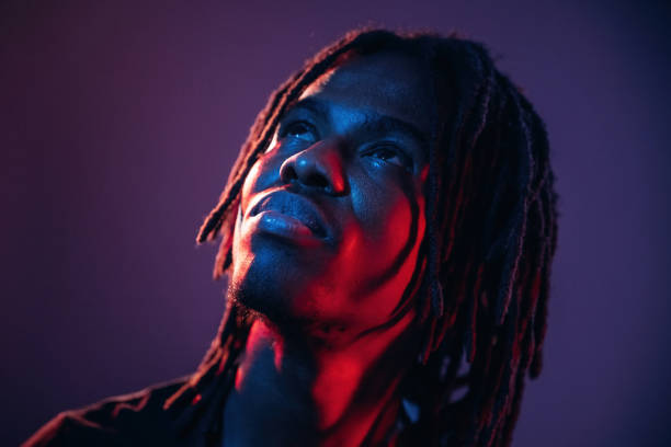 istock Close up portrait. African American guy is studio with neon lighting 2200180074