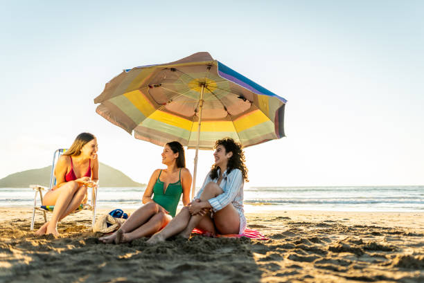 istock Young friends women talking on the beach 2200180106