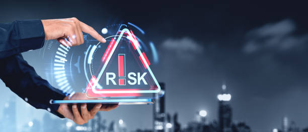 istock Man hand with tablet and finger touch red risk sign hologram. Copy space 2200180184