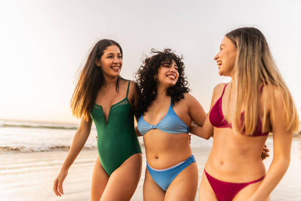 istock Friends women talking and walking through the beach 2200180279