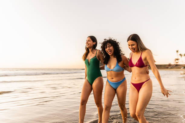 istock Friends women talking and walking through the beach 2200180292