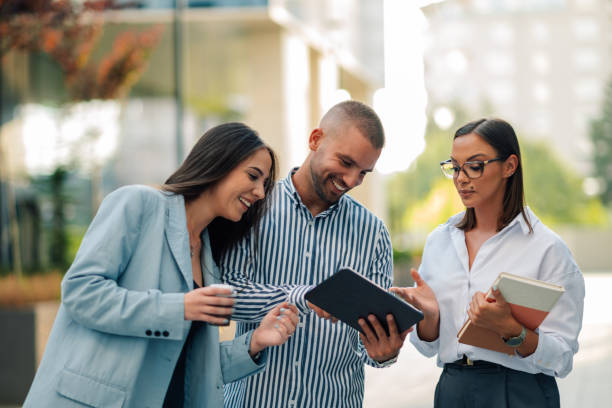 istock Three businesspeople having fun while working with a digital tablet outdoors 2200182376