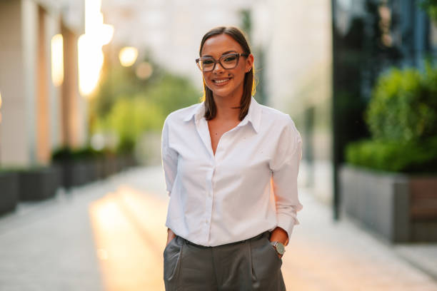 istock Businesswoman smiling outdoors with hands in pockets 2200182512