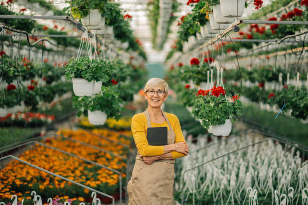 istock Old botanist at hothouse with tablet smiling at the camera. 2200186385