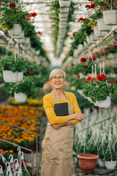 istock Confident old botanist with tablet at hothouse smiling at the camera. 2200186421