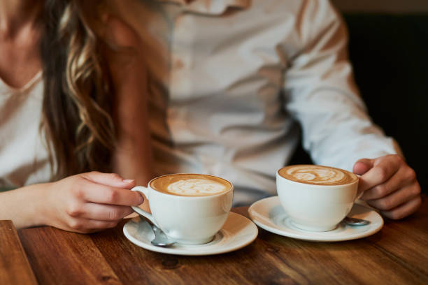 istock Cafe, love and hands of couple with coffee on date for bonding, relationship and commitment. Dating, closeup and man and woman with caffeine beverage, drink and cappuccino for breakfast in restaurant 2200186697