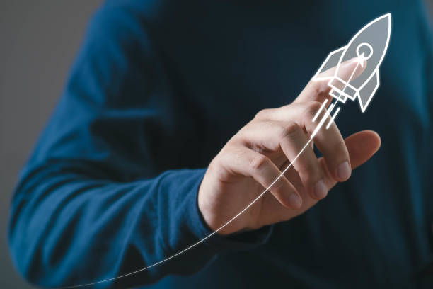 istock Innovative startup concept with hand drawing rocket launch symbolizing growth and success in business and technology sectors against blue background. 2200187205