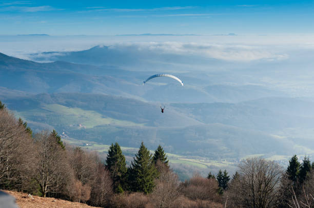 View of the Alsace plain with a paraglider who has just taken off from the top of the mountain.