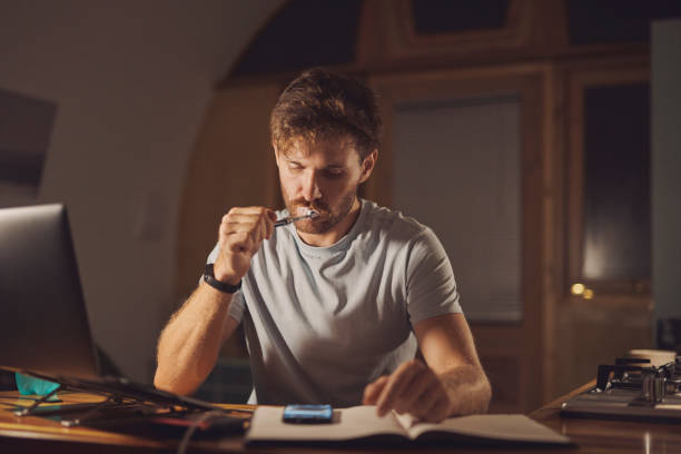 istock Home office, online and man with smartphone, brushing teeth and multitasking for project, reading or night. Remote work, web design and hygiene for dental care in house, workaholic or review of email 2200189057