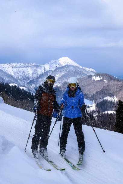 istock Couple skiers on snowy hill 2200189356