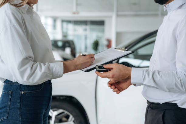 Holding keys for car. Close up view of man and woman is dealership stock photo