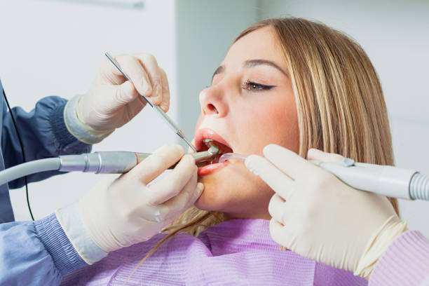 istock Dentist performing dental checkup on young woman's teeth 2200191736