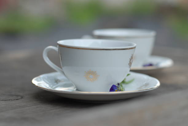 Vintage porcelain teacup with floral decoration on rustic wooden table