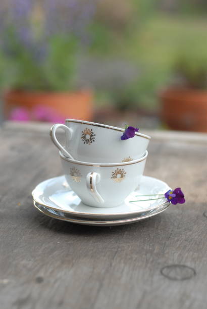 Vintage porcelain teacup with floral decoration on rustic wooden table