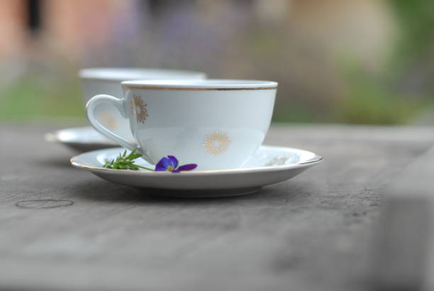 Vintage porcelain teacup with floral decoration on rustic wooden table
