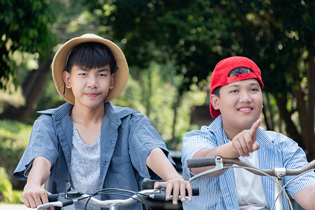 istock Boys riding bicycles in the park. 2200194420