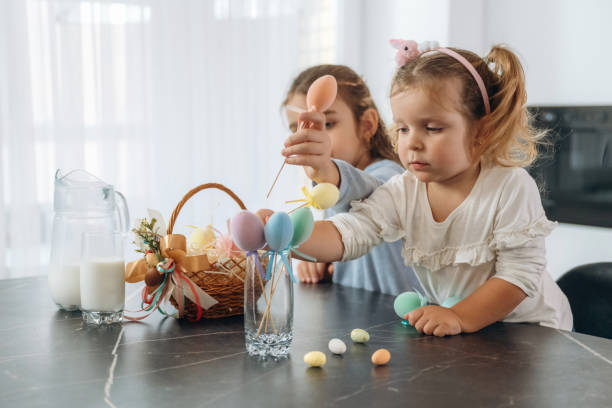 istock At kitchen, Easter eggs. Two little girls are preparing bakery at home 2200194776