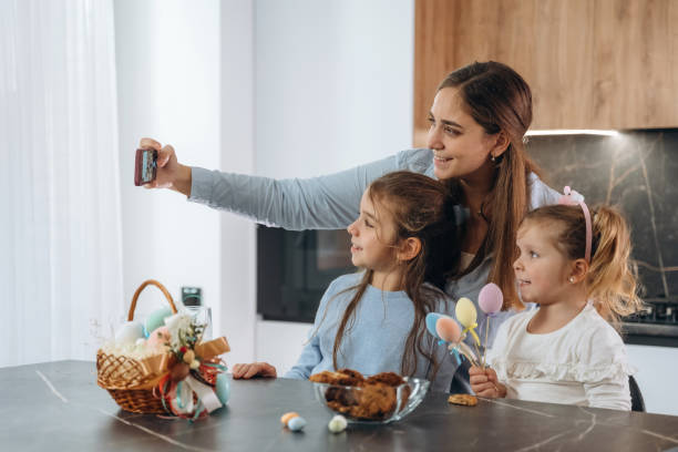 istock Making selfie. Mother with her little daughters preparing bakery 2200194900