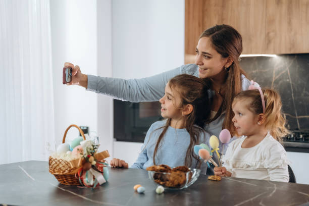 istock Making selfie. Mother with her little daughters preparing bakery 2200194909