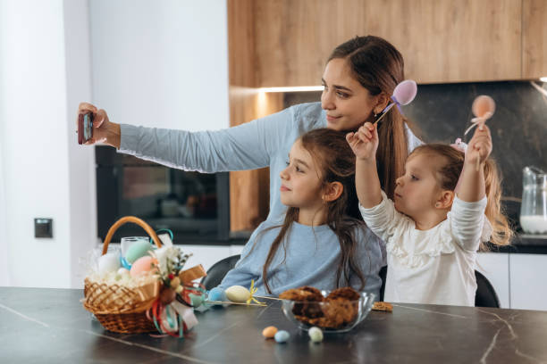 istock Making selfie. Mother with her little daughters preparing bakery 2200194951