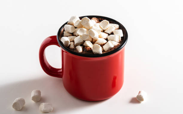 istock A red mug with a hot drink and marshmallows on a white table 2200195119